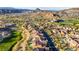 Expansive aerial view of a desert community showcasing lush landscaping and mountain views at 1223 Casa Palermo Cir, Henderson, NV 89011