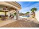 Outdoor living space with covered patio, wicker furniture, and a sparkling pool and lush landscaping at 1223 Casa Palermo Cir, Henderson, NV 89011