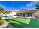 Inviting backyard with a sparkling pool, lush lawn, and a covered patio area for outdoor living at 1223 Casa Palermo Cir, Henderson, NV 89011