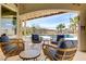 Covered patio with wicker furniture overlooking a sparkling pool and lush landscaping at 1223 Casa Palermo Cir, Henderson, NV 89011