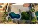 Overhead view of a kidney-shaped pool and spa with surrounding patio and green grass at 1223 Casa Palermo Cir, Henderson, NV 89011