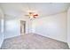 Large carpeted bedroom with ceiling fan and natural lighting from windows at 1580 S Outlaw St, Pahrump, NV 89060