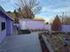 Backyard area featuring synthetic grass, colorful garden and a storage shed at 18 Allegro St, Blue Diamond, NV 89004