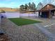 Spacious backyard featuring artificial turf, gravel landscaping, shed, and covered patio at 18 Allegro St, Blue Diamond, NV 89004