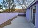 Exterior view of the home's side yard showcasing a concrete patio and desert landscaping at 18 Allegro St, Blue Diamond, NV 89004