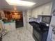 Galley kitchen features white cabinets, black appliances, and marble tile floors at 18 Allegro St, Blue Diamond, NV 89004