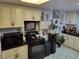 Kitchen featuring black appliances, light colored cabinets and black countertops at 18 Allegro St, Blue Diamond, NV 89004