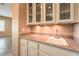 Home wet bar features granite countertops and glass shelves with a sink and neutral cabinetry at 1964 Oliver Springs St, Henderson, NV 89052