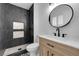 Contemporary bathroom features dark tile shower, sleek fixtures, and a stylish natural wood vanity at 2058 Citroen St, Las Vegas, NV 89142