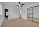 Bedroom with mirrored closet doors, ceiling fan, and attached bathroom with black tile at 2058 Citroen St, Las Vegas, NV 89142