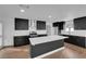 A modern kitchen featuring black cabinets, stainless steel appliances, and a bright white island at 2058 Citroen St, Las Vegas, NV 89142