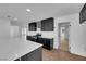 Modern kitchen with island, dark cabinets, white countertops, and wood-look floors at 2058 Citroen St, Las Vegas, NV 89142