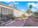 A backyard featuring desert landscaping, a paved walkway, and a secure gated utility area at 2136 Velvet Hill Ave, Las Vegas, NV 89106