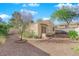 Exterior view of backyard featuring desert landscaping, a covered porch, and mature trees at 2136 Velvet Hill Ave, Las Vegas, NV 89106