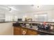 Bright kitchen featuring stainless steel sink, dark granite countertops and adjacent living area at 2510 Influential Ct, North Las Vegas, NV 89031