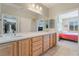 Bathroom featuring double sinks, wood cabinetry, and a view into the bedroom at 2633 Flare Star Dr, Henderson, NV 89044