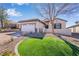 Charming home with landscaped front yard, circular patch of grass, and two-car garage at 2633 Flare Star Dr, Henderson, NV 89044