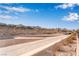 A desert landscape with homes in the background beneath a blue sky and puffy clouds at 2633 Flare Star Dr, Henderson, NV 89044