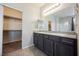 Bathroom features dual sink vanity, granite countertop, large mirror, and open walk-in closet at 2721 Benton Cove St, Laughlin, NV 89029