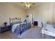 Bedroom featuring carpet floors, neutral walls, a ceiling fan and door leading to bathroom at 2721 Benton Cove St, Laughlin, NV 89029