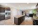 Open floor plan showcasing the kitchen island with seating, stainless steel appliances, and tile floors at 2721 Benton Cove St, Laughlin, NV 89029