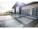 Striking modern home featuring desert landscaping, an artfully patterned driveway, and glass garage doors at 3030 S Formula Ct, Pahrump, NV 89048