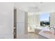 Bright main bathroom featuring dual sinks, a glass-enclosed shower, and a soaking tub with a city view at 322 Karen Ave # 808, Las Vegas, NV 89109