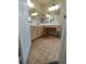 Tiled bathroom featuring a double-sink vanity with overhead lighting and neutral wall colors at 326 Lander Dr, Henderson, NV 89074