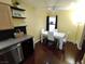 Kitchen eat-in dining area featuring hardwood floors, modern appliances, and stylish white table and chairs at 326 Lander Dr, Henderson, NV 89074