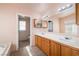 Well-lit bathroom featuring a double vanity with wood cabinets and large mirrors at 3420 Malibou Ave, Pahrump, NV 89048