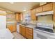 Bright kitchen features wood cabinetry, white appliances, and natural light from a window with views at 3420 Malibou Ave, Pahrump, NV 89048