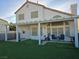 Exterior view of the backyard features a covered patio with furniture, green turf, and stucco exterior at 3550 Leor Ct, Las Vegas, NV 89121