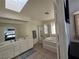 Spacious bathroom with double sinks, a jetted tub, and natural light from a skylight at 3550 Leor Ct, Las Vegas, NV 89121