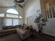 Bright living room featuring large windows, a vaulted ceiling, and neutral-toned furniture at 3550 Leor Ct, Las Vegas, NV 89121