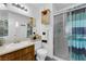 Well-lit bathroom features a vanity, toilet, mirrored cabinet and a shower with glass door at 3936 Savoy Ct, Las Vegas, NV 89115