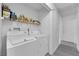 Well-lit laundry room includes a washing machine, dryer, and overhead wire shelving for storage at 3936 Savoy Ct, Las Vegas, NV 89115