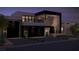 Modern home exterior with a two-car garage, black accents, and a second-story balcony at night at 4337 Cameron Brook Ct, Las Vegas, NV 89129