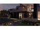 Contemporary home exterior featuring a black garage door, balcony, and manicured landscaping at night at 4337 Cameron Brook Ct, Las Vegas, NV 89129