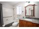 Cozy bathroom with a granite countertop, wood vanity, shower-tub combo, and decorative mirror at 4746 Rosalie Cir, North Las Vegas, NV 89031