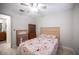 Neutral spare bedroom with a ceiling fan, a window, a view to the hallway, and tile floors at 4746 Rosalie Cir, North Las Vegas, NV 89031