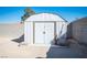 An outdoor white storage shed with a double door in a large backyard with block wall fencing at 4746 Rosalie Cir, North Las Vegas, NV 89031