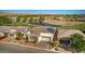 Aerial view of a desert home featuring a tile roof, a two-car garage, desert landscaping, and an adjacent golf course pond at 4775 E Beacon Ridge Dr, Pahrump, NV 89061