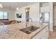 Kitchen island with stainless steel sink and faucet, granite countertops, and white cabinets at 4775 E Beacon Ridge Dr, Pahrump, NV 89061