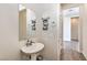 Well-lit powder room with a pedestal sink, mirror, and decorative towel rack at 4775 E Beacon Ridge Dr, Pahrump, NV 89061