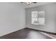 Bright bedroom with ceiling fan, wood-look floors, white walls, and a large window at 4775 Monaco Rd, Las Vegas, NV 89121