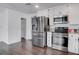 Modern kitchen boasts stainless steel appliances, white cabinetry, and wood-look flooring at 4775 Monaco Rd, Las Vegas, NV 89121