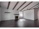 Spacious living room features a white-brick fireplace, wood flooring, and vaulted ceilings with wood beams at 4775 Monaco Rd, Las Vegas, NV 89121