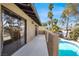 Balcony view showcases an in-ground pool with palm trees against a clear blue sky at 5102 Tennis Ct, Las Vegas, NV 89120