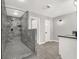 Bathroom features modern gray tiled shower with black fixtures, vanity with gray countertop, and gray tiled floors at 5102 Tennis Ct, Las Vegas, NV 89120