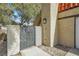 Inviting entrance with brick accent wall, wrought iron gate, and desert landscaping at 5102 Tennis Ct, Las Vegas, NV 89120